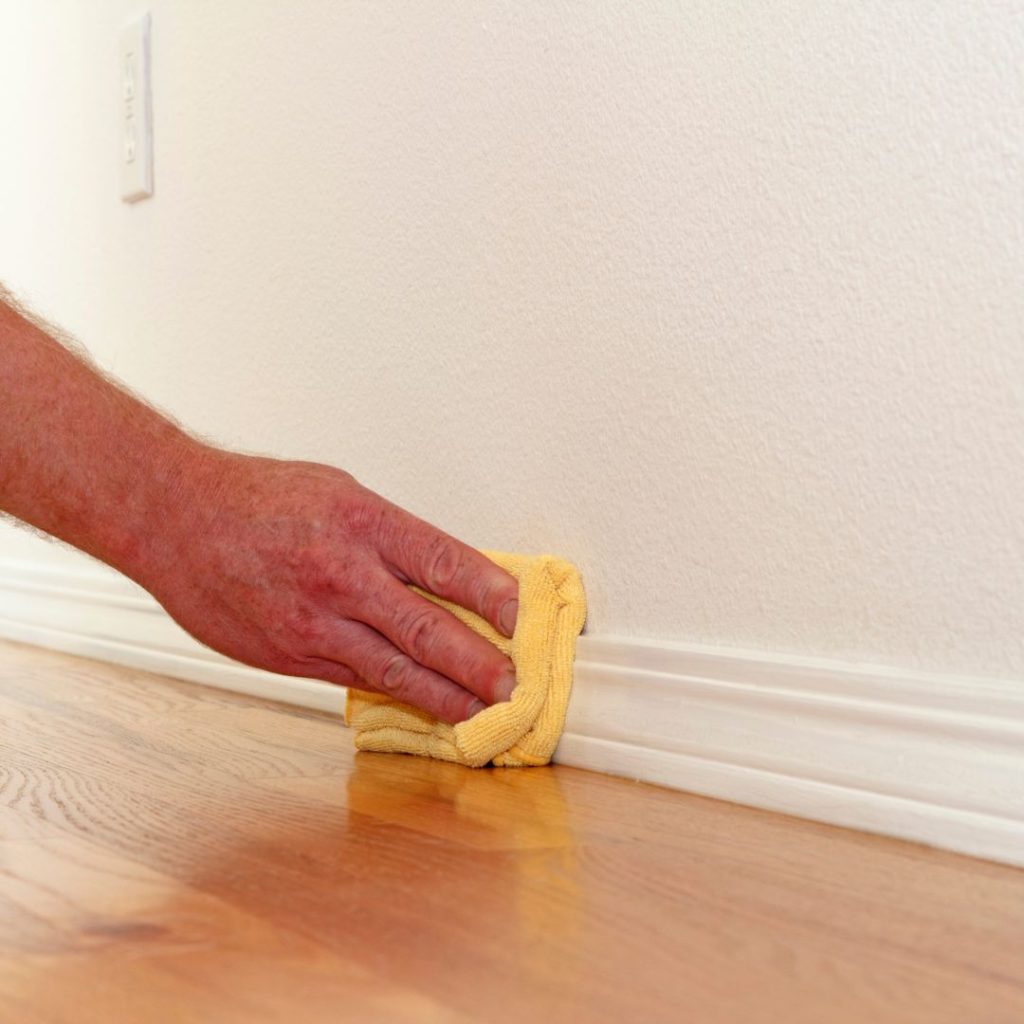 House cleaner wiping baseboards